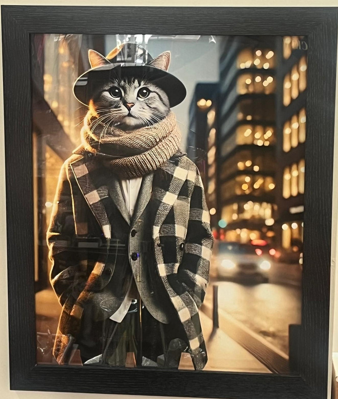 Black framed picture of a cat wearing beige coat, scarf & hat wall art decor